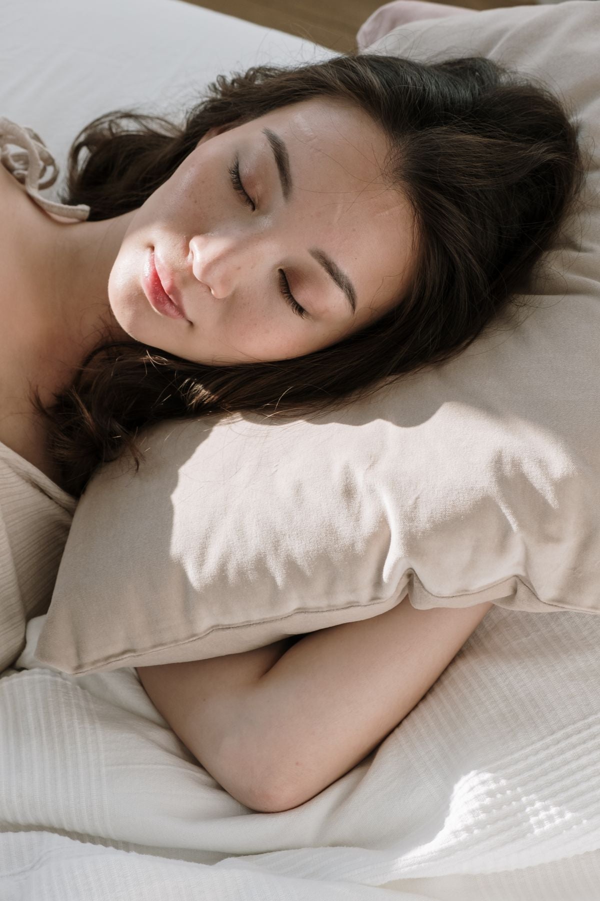 Persona durmiendo de costado con la cabeza apoyada en una almohada.